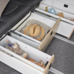 Gros plan sur les tiroirs sous la banquette coulissant d'un van aménagé